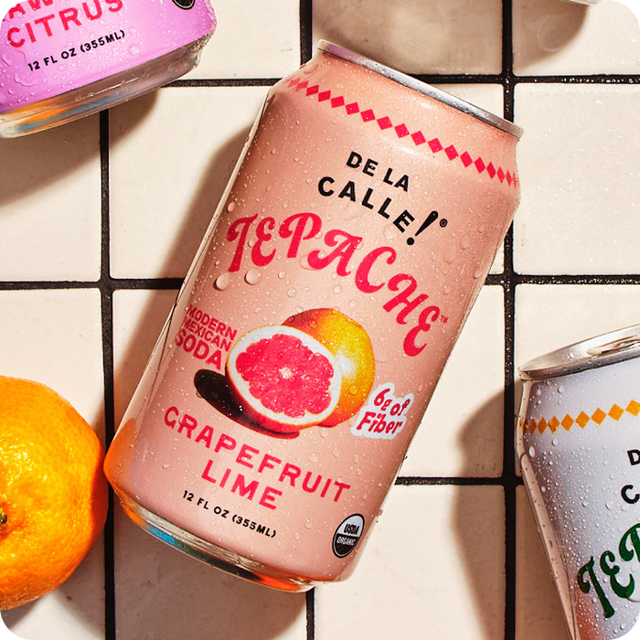 Can of De La Calle TePache Grapefruit Lime soda on a tiled surface with an orange next to it.