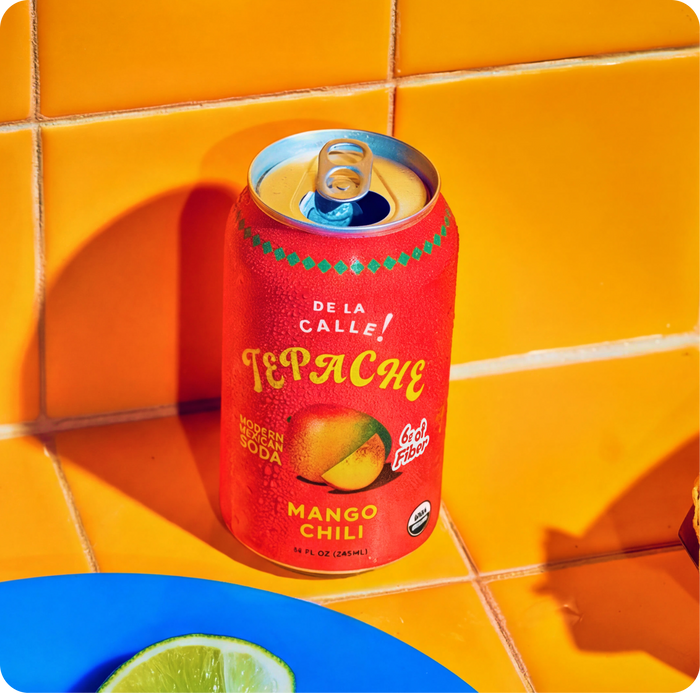 Red can of TePache Mango Chili soda on a yellow tiled surface
